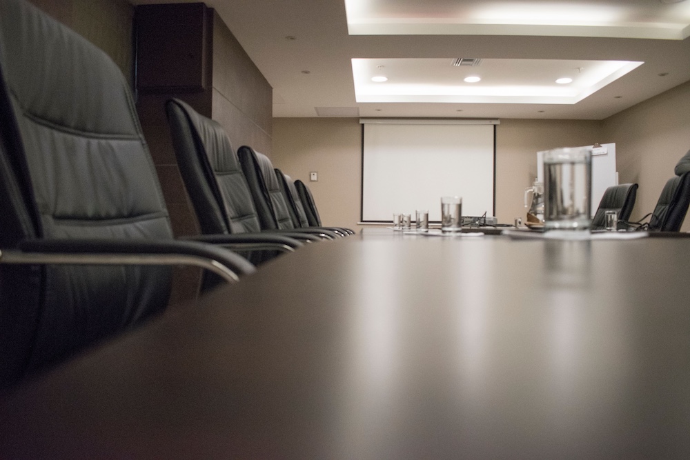 An empty boardroom table, where the AI directive is taken